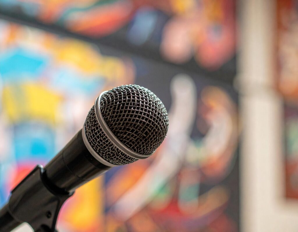Microphone in front of a colorful backdrop, representing interviews and creative conversations.